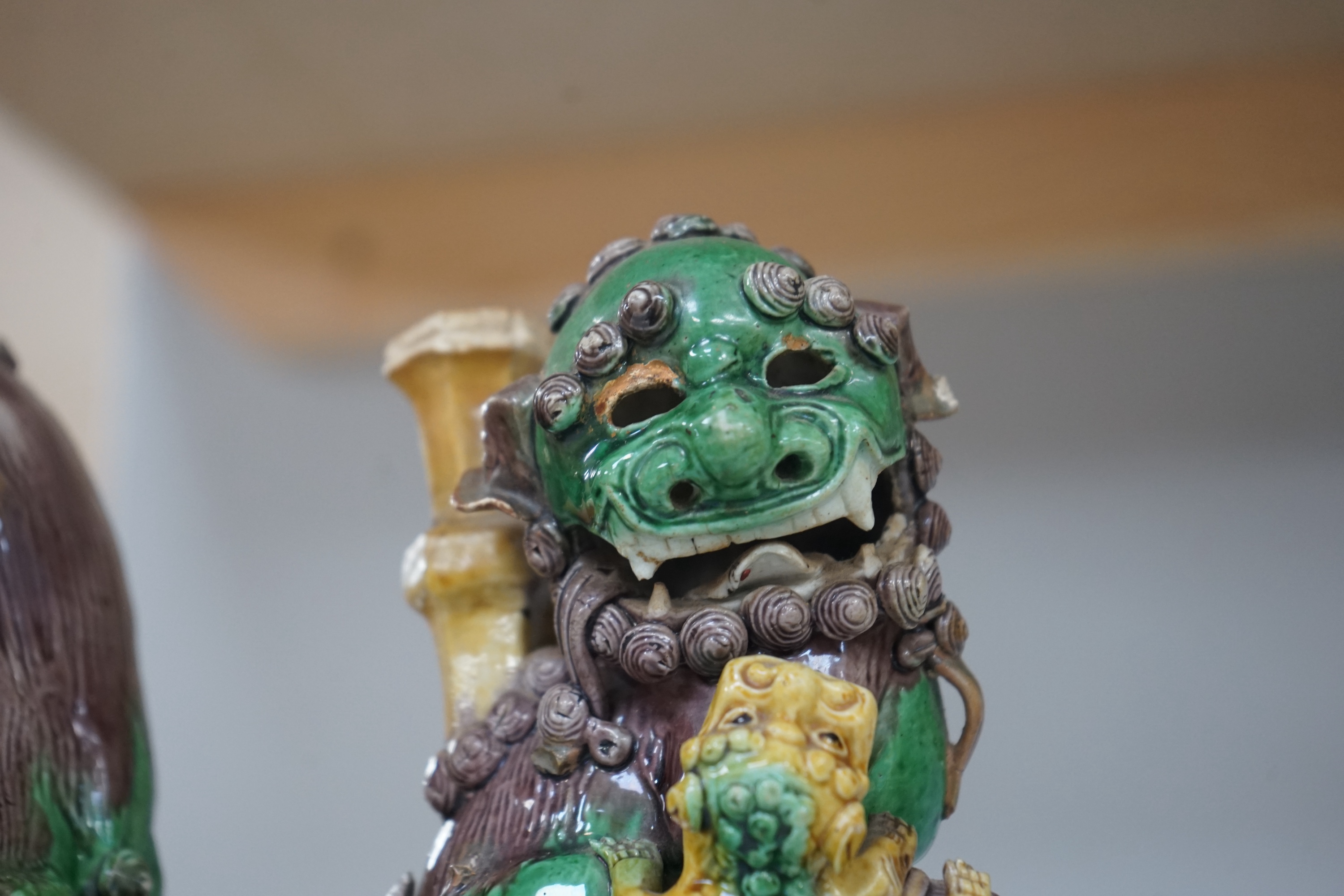 A pair of Chinese Sancai glazed lion joss stick holders, 18th century, 17cm high. Condition - some restoration